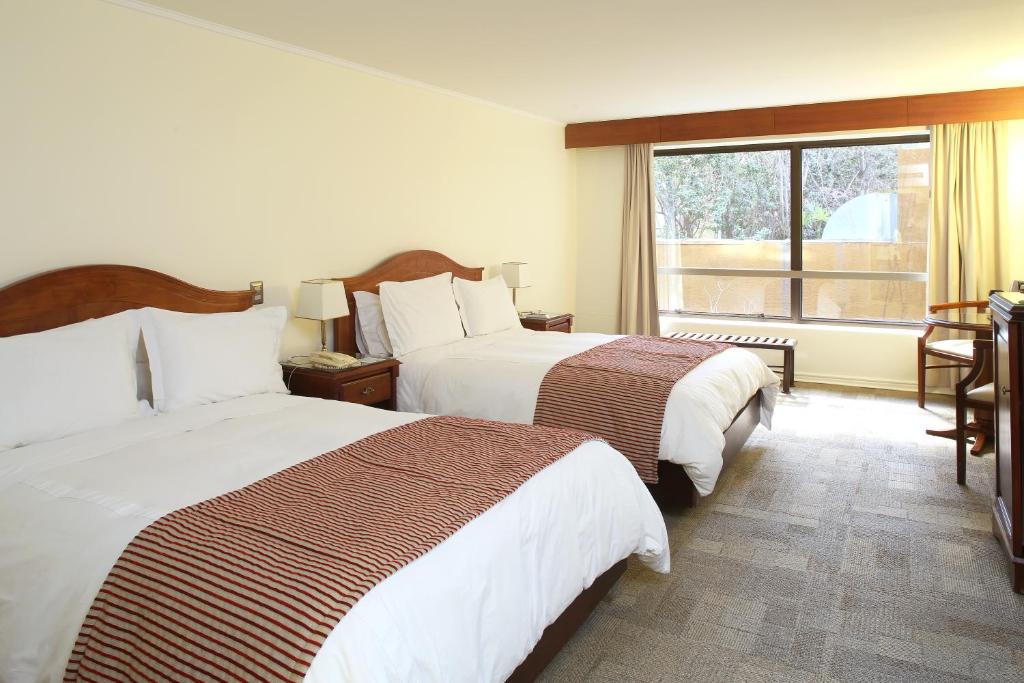 Postel nebo postele na pokoji v ubytování MR Hotel Providencia (ex Hotel Neruda)