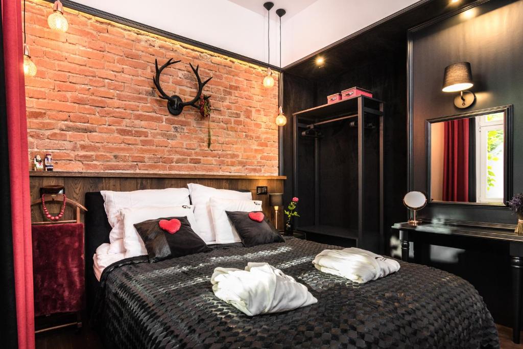 1 dormitorio con pared de ladrillo y cama con almohadas en Wooden Horse - New Apartment - Old Town, en Cracovia