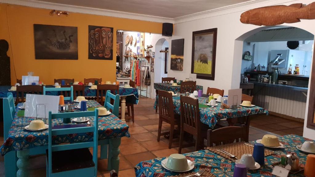 a restaurant with tables and chairs in a room at Bamboo, the Guesthouse in Knysna