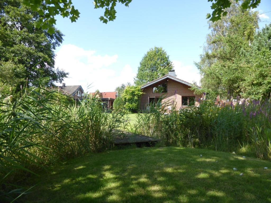 un jardín con un banco en medio de un patio en Ferienhaus Torsholt, en Westerstede