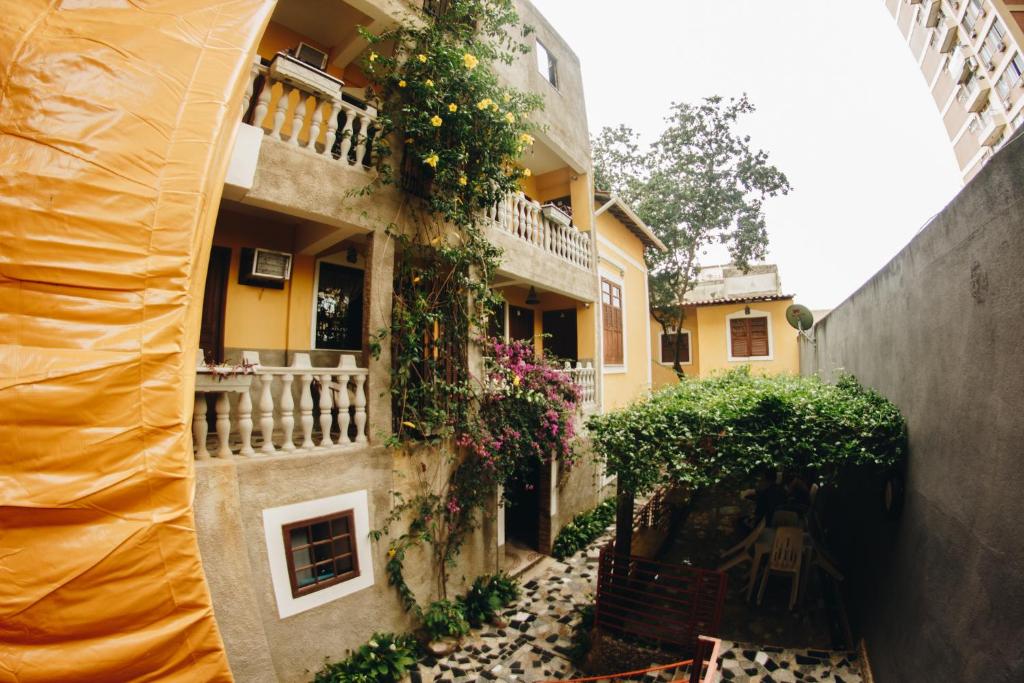 een steegje met een gebouw met bloemen en planten bij Hostel Da Bruna - Botafogo in Rio de Janeiro