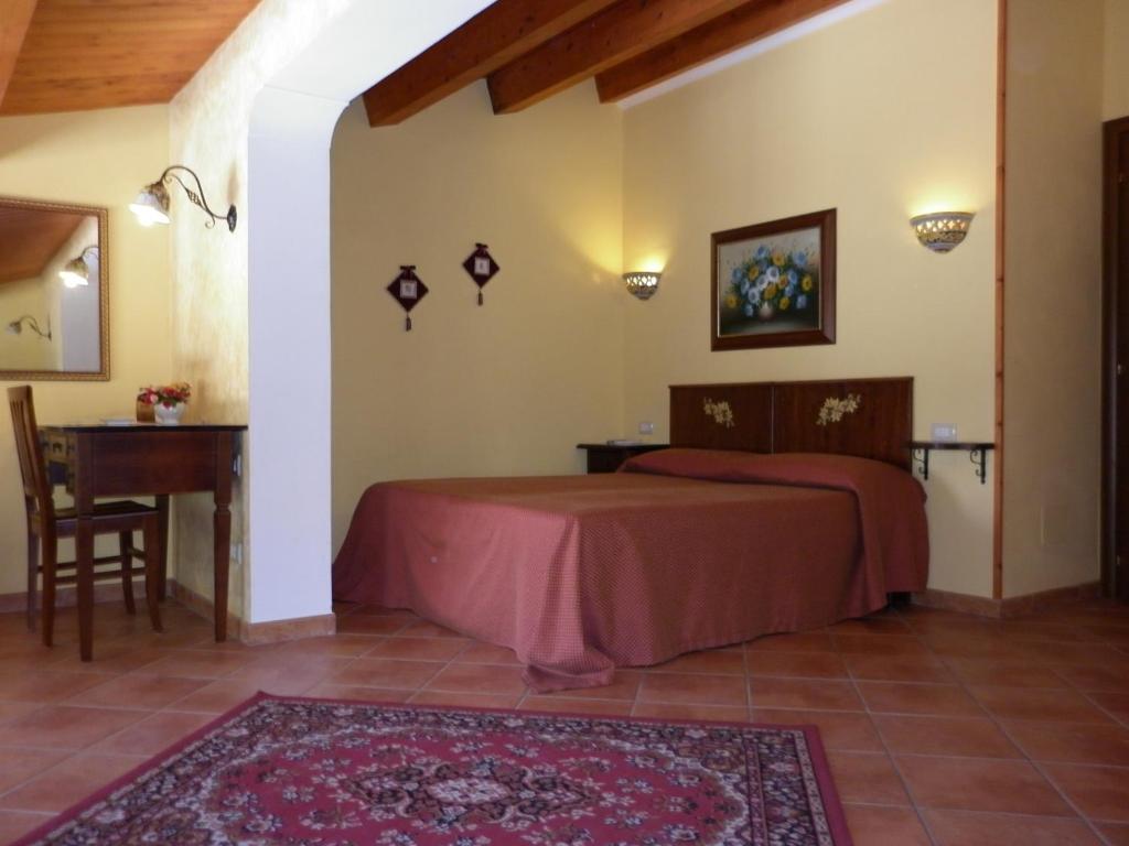 1 dormitorio con cama, mesa y escritorio en B&B Triskèles, en Siracusa