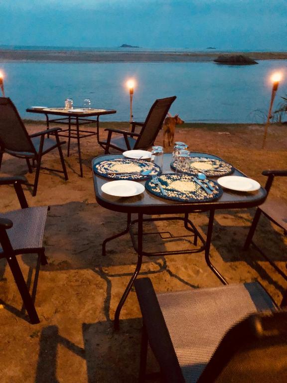 a table and chairs on the beach at night at C Beyond Nilaveli in Nilaveli