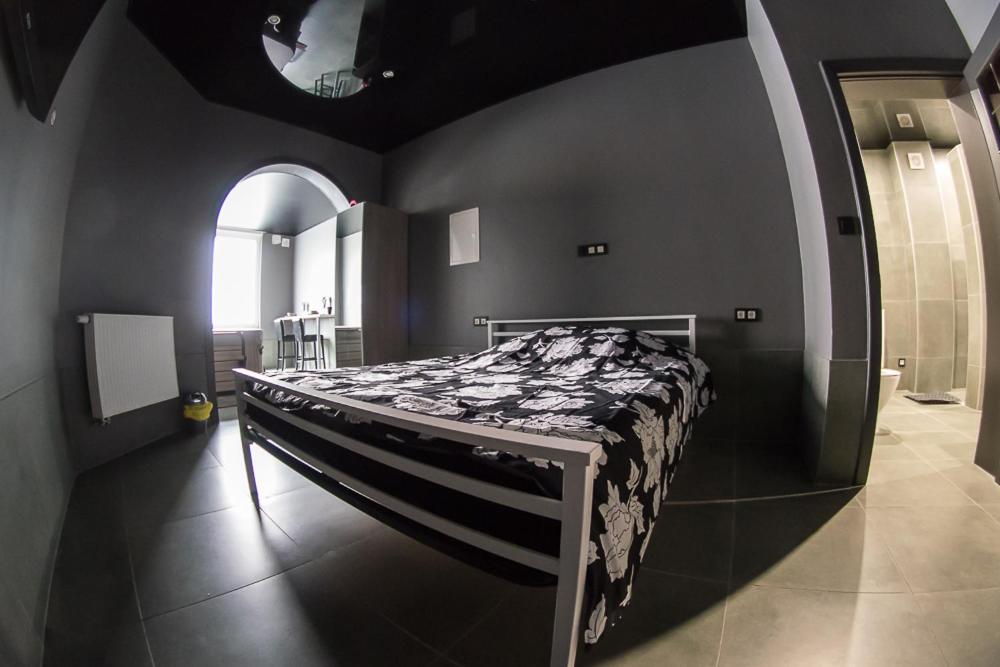 a bedroom with a bed in a room with an arch at Appartement Studio Tournai in Tournai