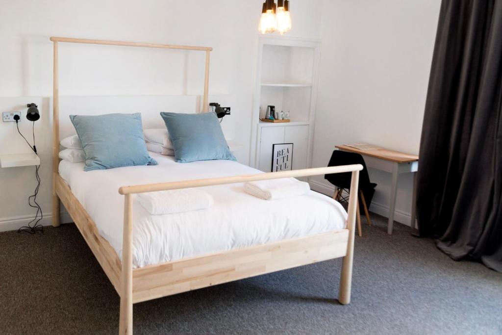 1 dormitorio con cama de madera y almohadas azules en The Black Fox, en Bath