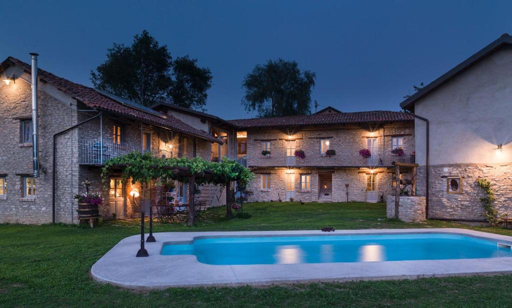 a house with a swimming pool in the yard at Cascina Facelli - Luxury Country House in Bossolasco