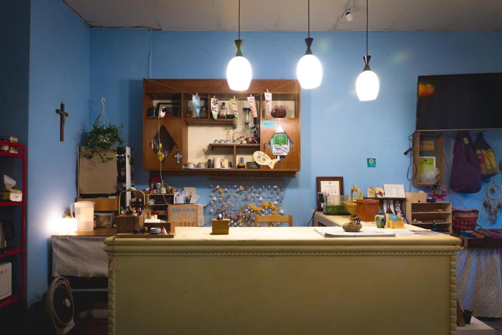 a blue room with a counter with pendant lights at Fish Hostel in Yingge