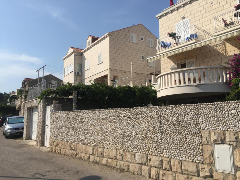 a stone wall next to a building with a balcony at Apartment Dubcic: For perfect vacation in Dubrovnik