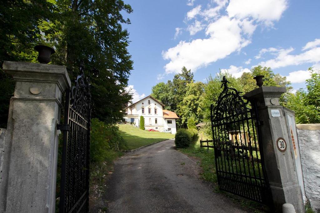 a gate to a driveway with a house in the background at Maison d hotes villa les pervenches in La Chaux-de-Fonds