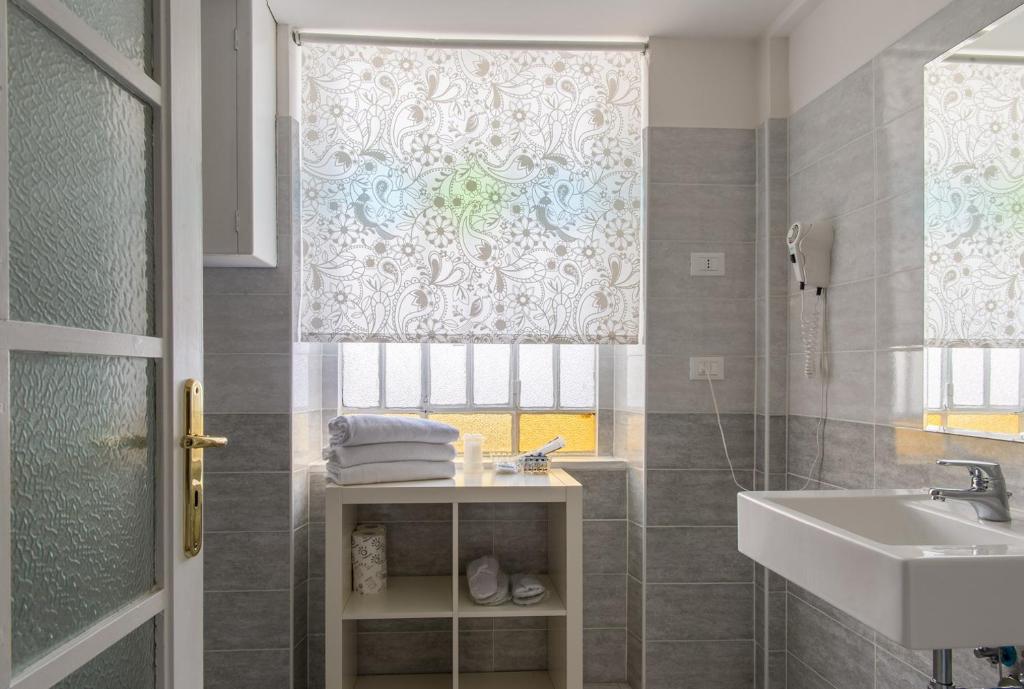 baño con lavabo y ducha con ventana en Hotel Alpi Resort, en Turín