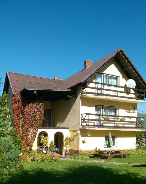 une grande maison avec un toit rouge dans l'établissement Agroturustyka Grazyna Ksel Korbielow ul slepa dolina 2, à Korbielów