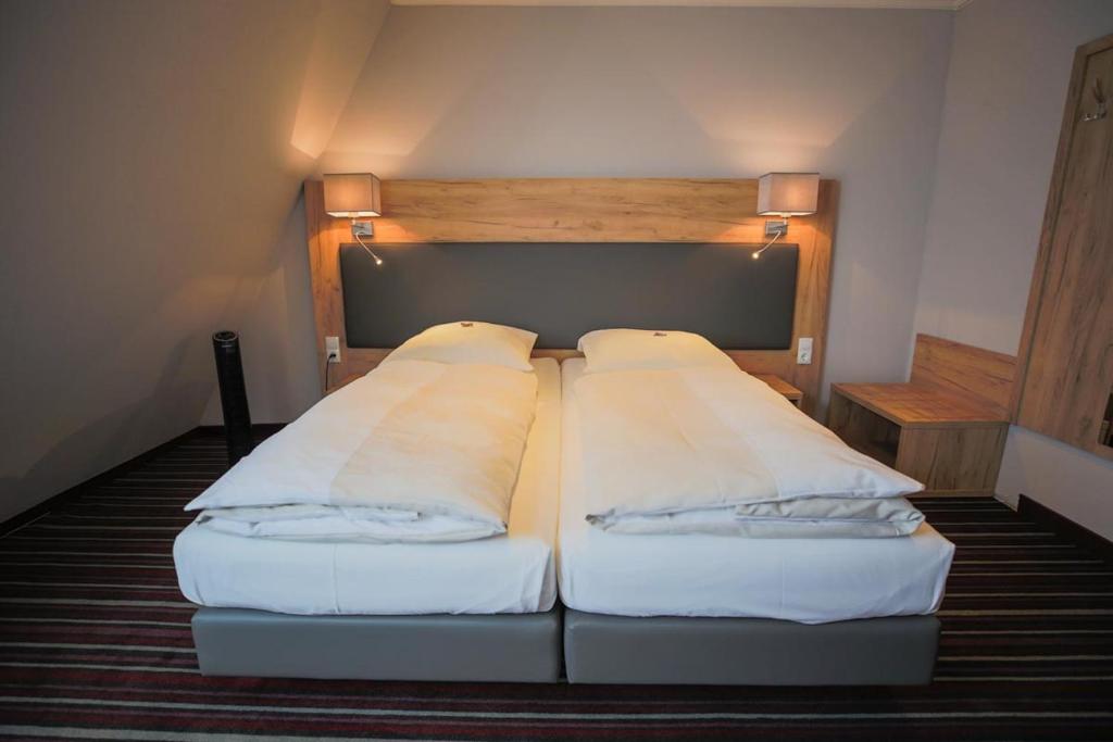 a bed with two pillows on it in a room at Hotel Süderelbe in Hamburg