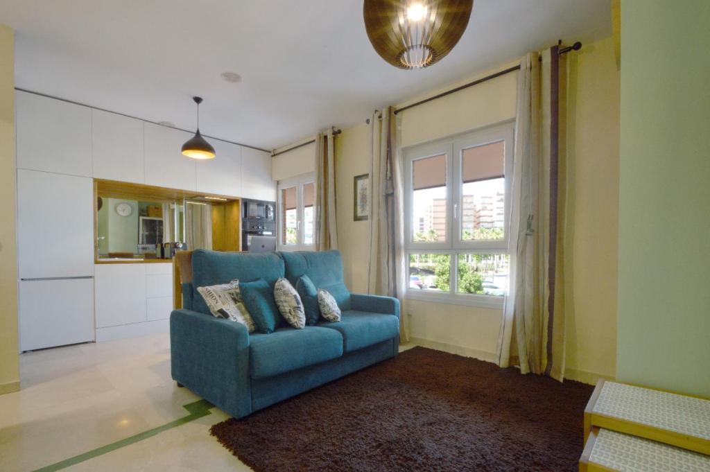 アルメリアにあるModerno apartamento frente a la playa y el centroの窓付きのリビングルーム(青いソファ付)