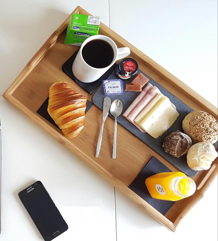 a tray with food and a cup of coffee and pastries at Almada Story Apartments by Porto City Hosts in Porto