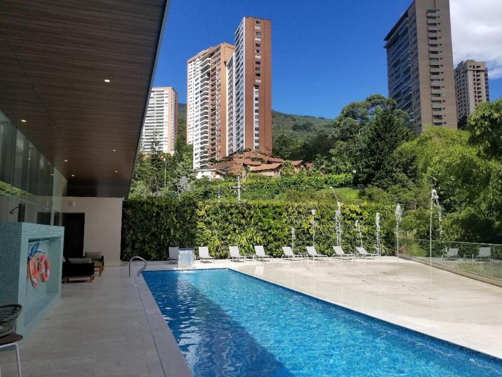 a swimming pool with water fountains in a building at Estelar La Torre Suites in Medellín