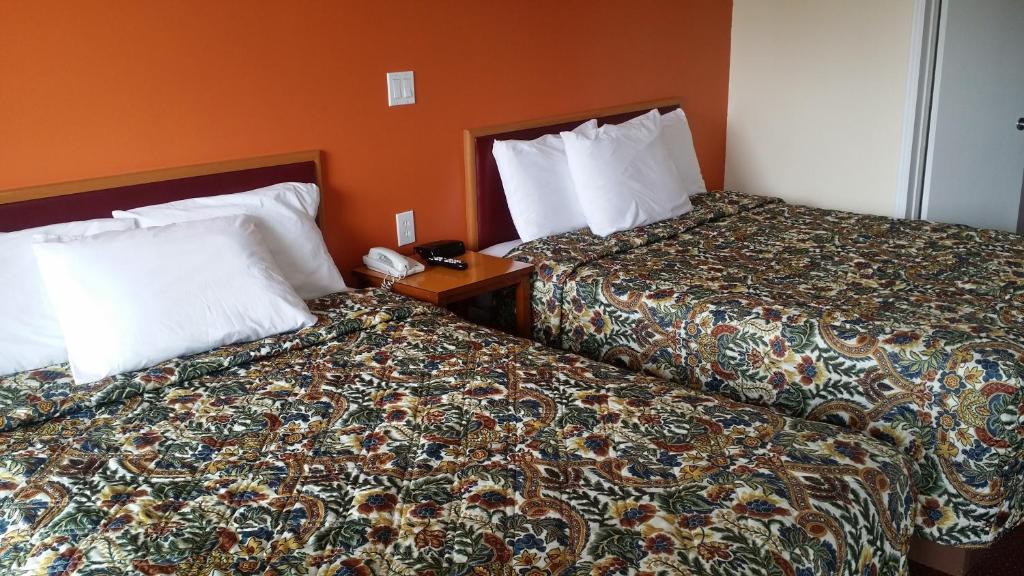 dos camas sentadas una al lado de la otra en una habitación de hotel en River Mist Inn, en Sturgeon Falls