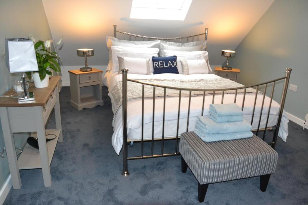 um quarto com uma cama com almofadas brancas e uma secretária em Little Dene Apartment em Salisbury