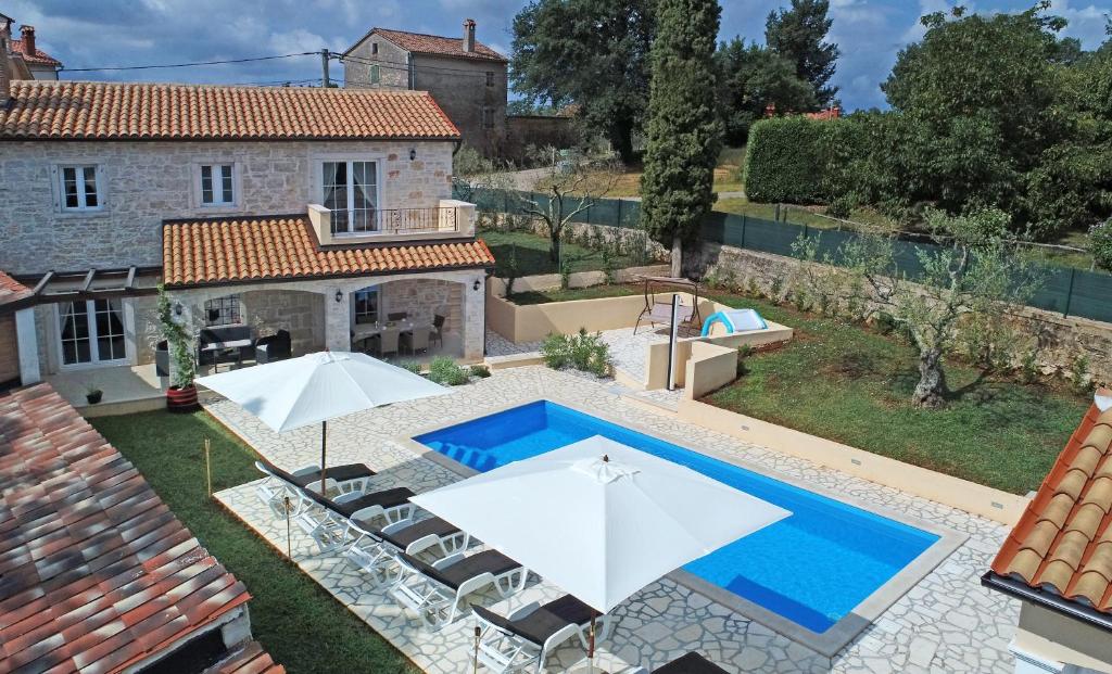 an image of a villa with a swimming pool and umbrellas at Villa Emilia in Vižinada