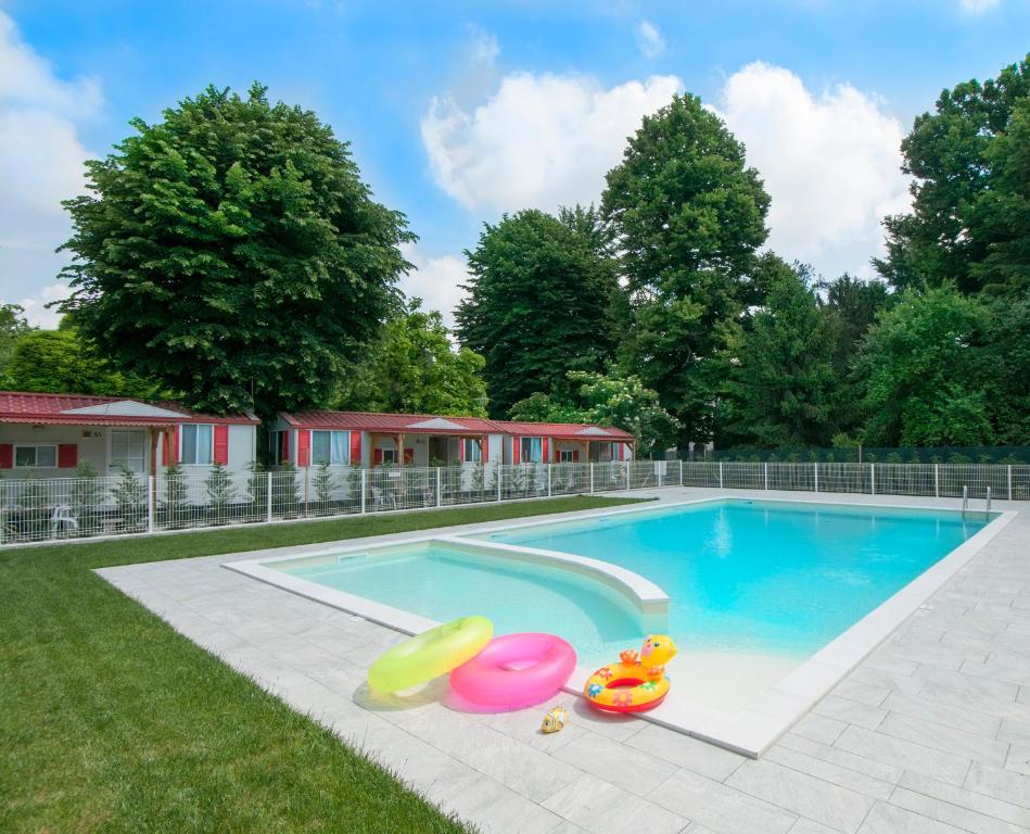 a swimming pool with inflatable toys in the grass at Camping Serenissima in Malcontenta