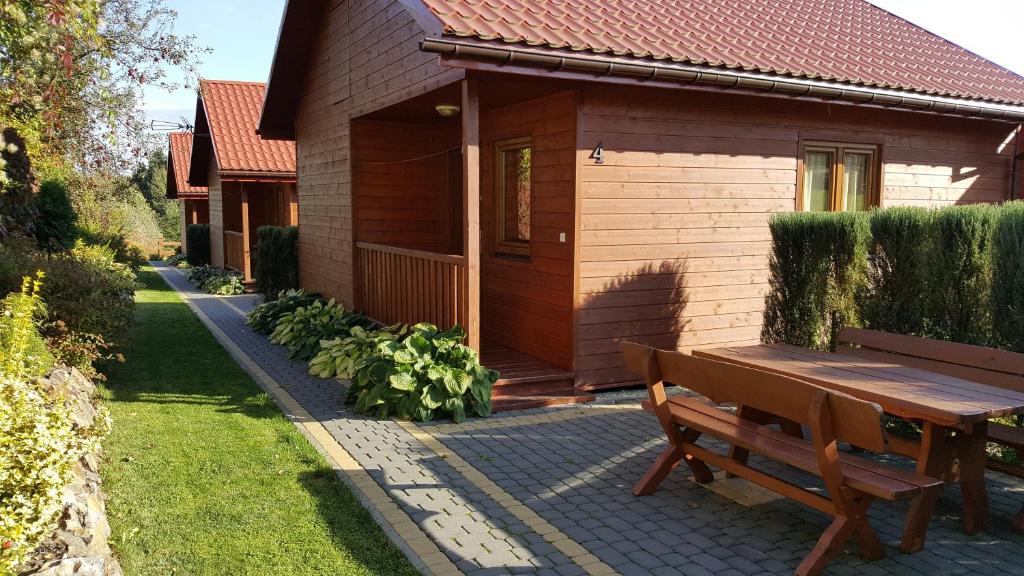 a wooden house with a bench in front of it at Domki Irena Kozdrowska in Polańczyk