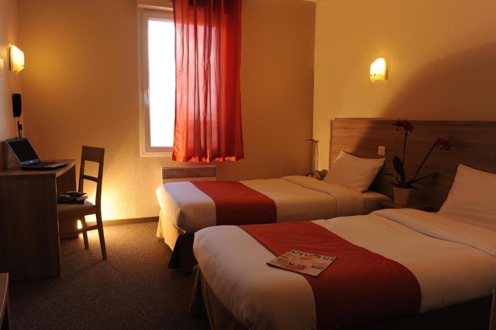 a hotel room with two beds and a window at Hotel Salea in Pornic