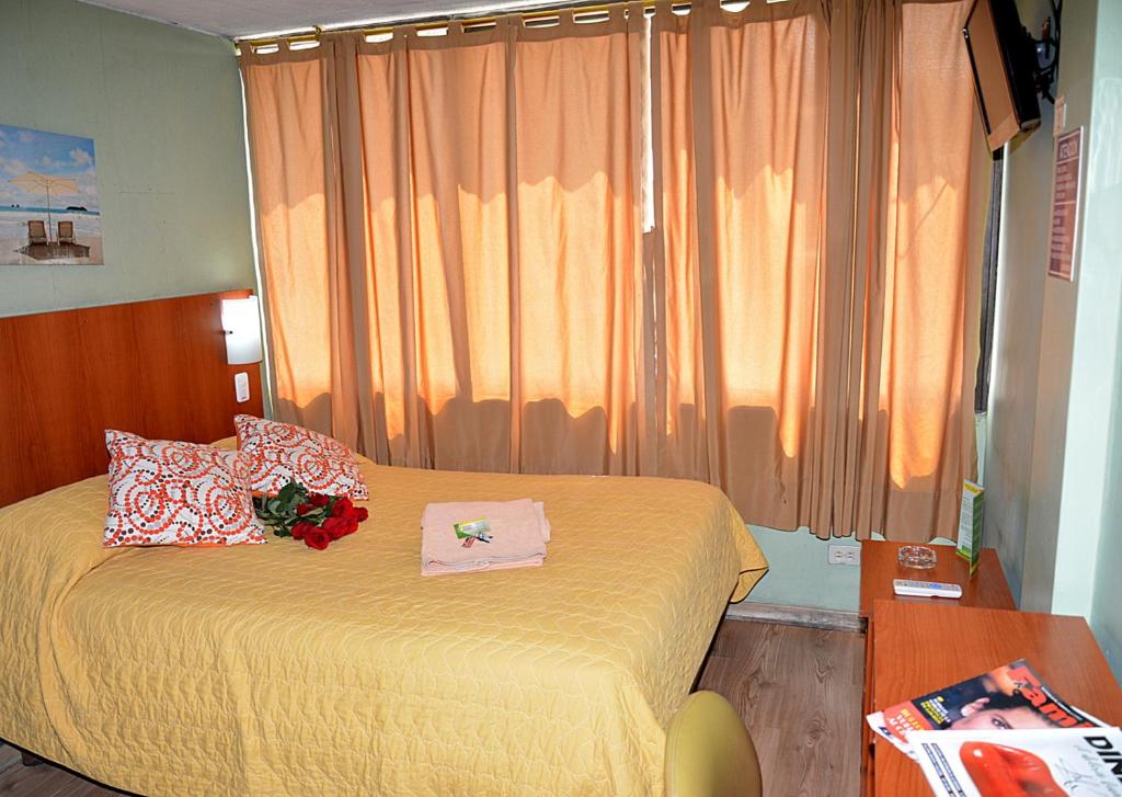 1 dormitorio con 1 cama con colcha amarilla en Hostal Terra 1 - ANDALUCÍA, en Quito