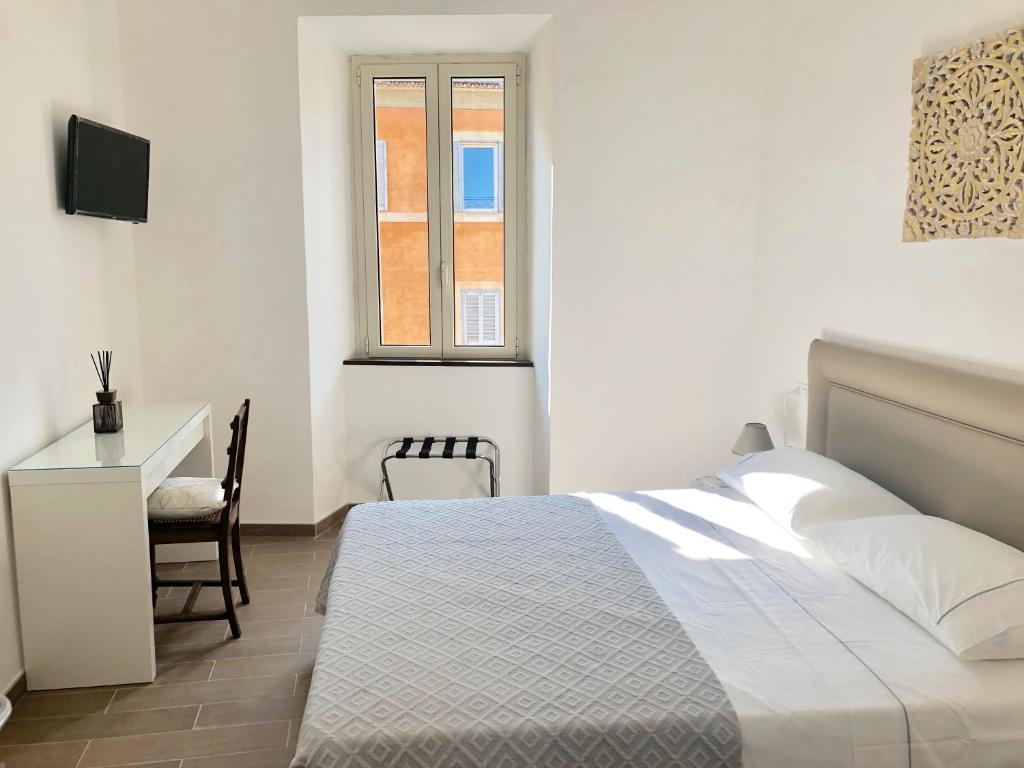 een slaapkamer met een bed, een bureau en een raam bij S.Apollonia Suite Trastevere in Rome
