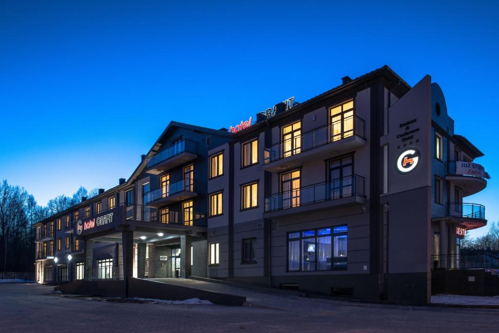a building with lights on in the night at Hotel Grafit in Kielce