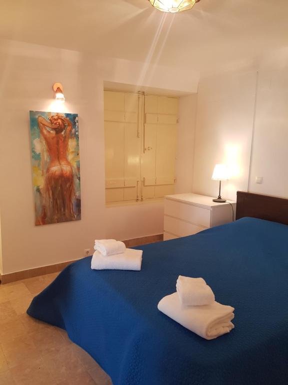 a bedroom with a blue bed with two towels on it at Casa Visconde de Alcácer in Setúbal