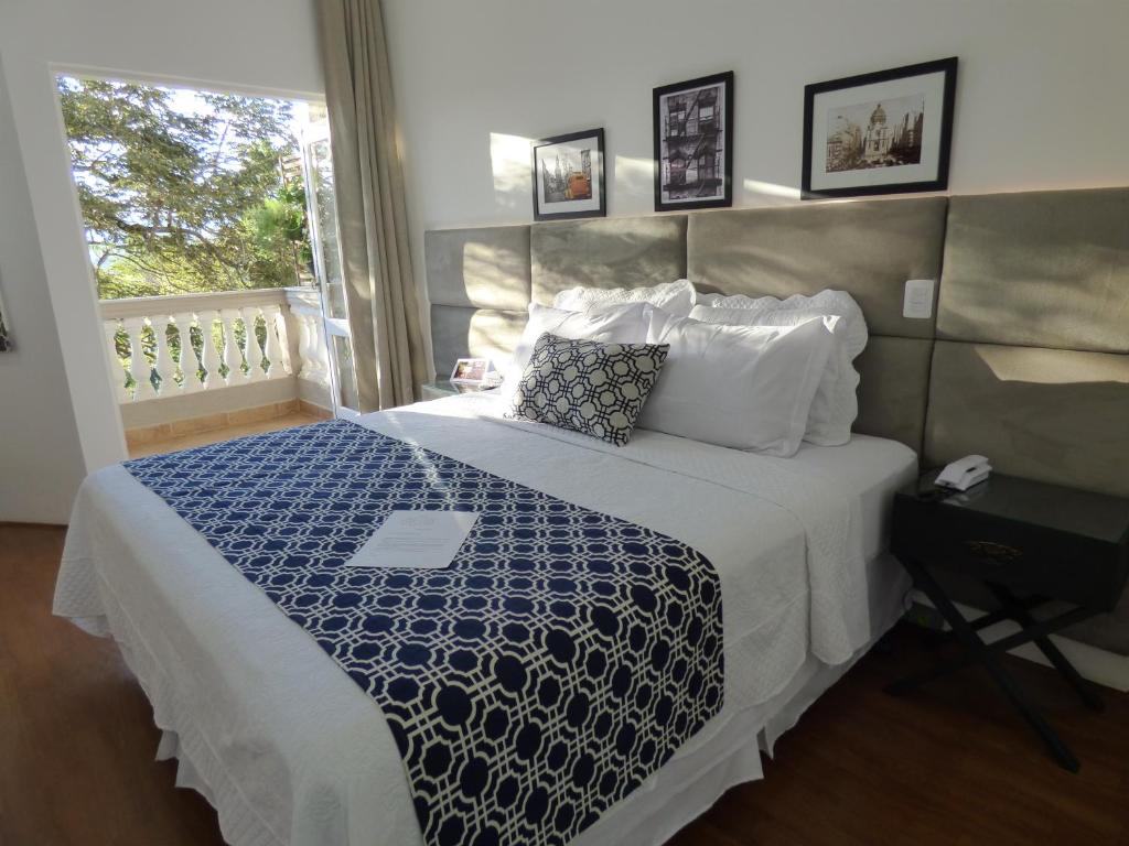 埃斯特雷馬的住宿－Feliccità Pousada，一间卧室配有一张带蓝色和白色棉被的床