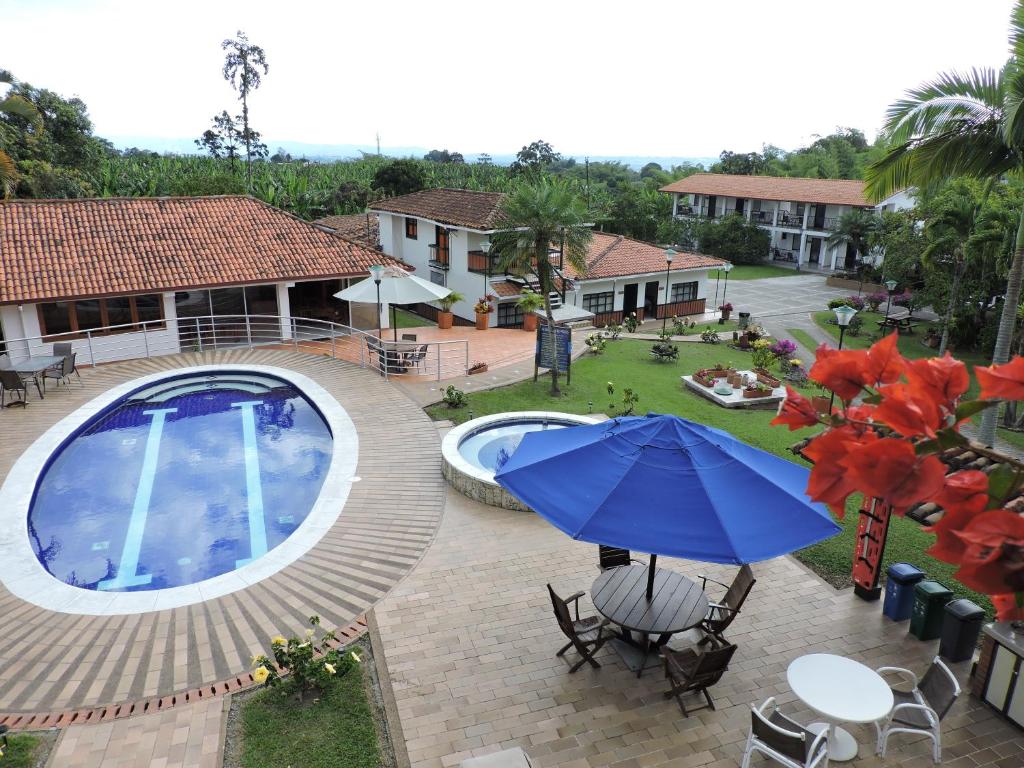 an overhead view of a pool with a blue umbrella at Finca Hotel Valparaíso in Armenia
