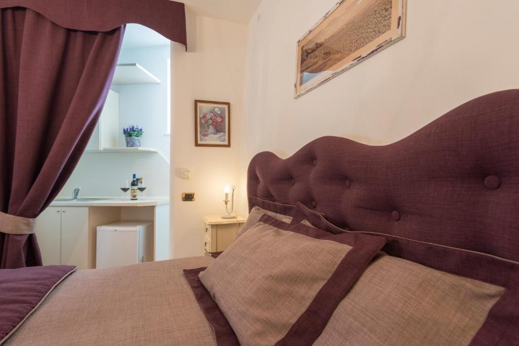 a bedroom with a bed with a brown headboard at Villa Goccia di Vino in La Morra