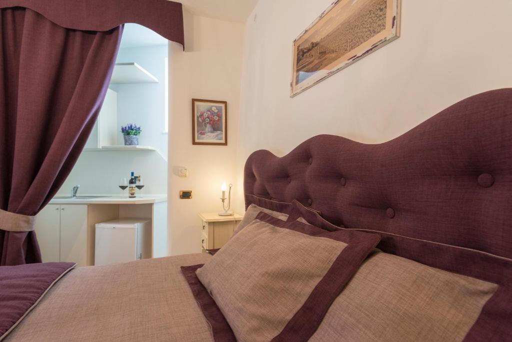 una camera con letto e testiera marrone di Villa Goccia di Vino a La Morra