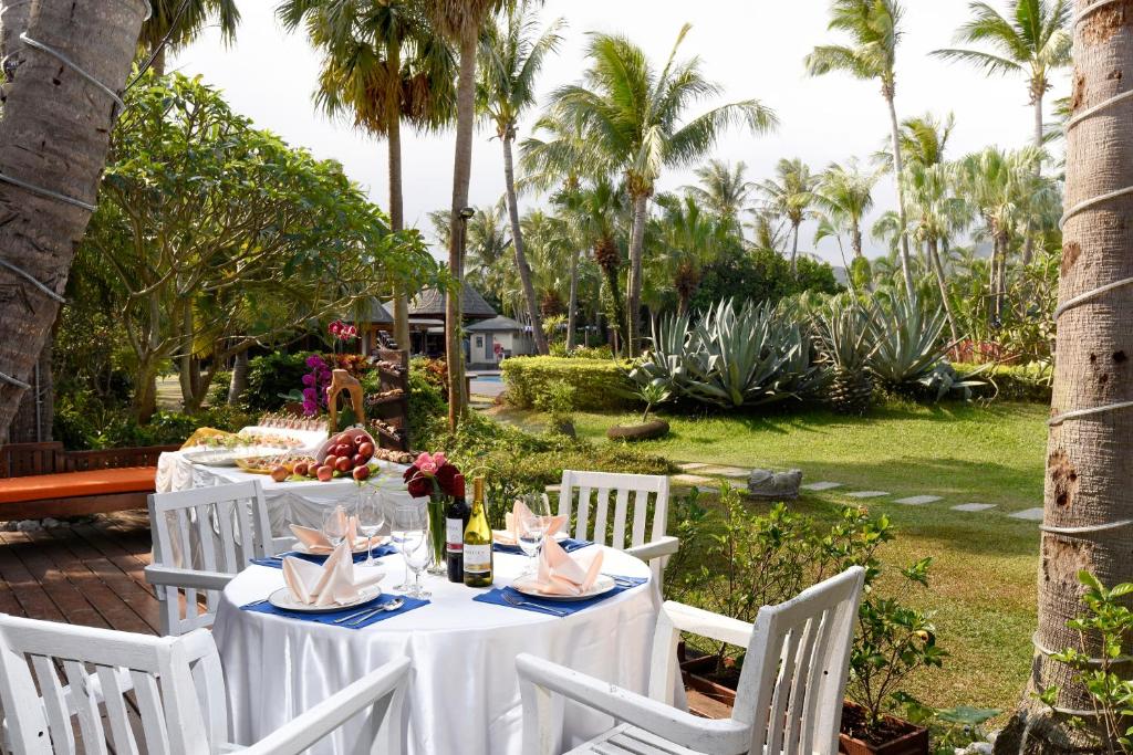 a table with white chairs and a table with food at Caesar Park Hotel Kenting in Kenting
