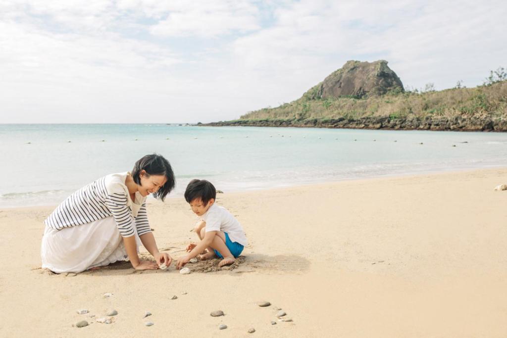 a woman and a child playing on the beach at Caesar Park Hotel Kenting in Kenting