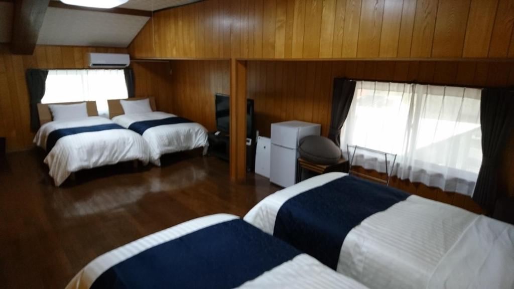 een hotelkamer met 2 bedden en 2 ramen bij Minpaku Nagashima room1 / Vacation STAY 1028 in Kuwana
