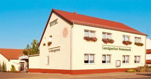 un gran edificio blanco con techo rojo en Landgasthof Sonneneck, en Listerfehrda