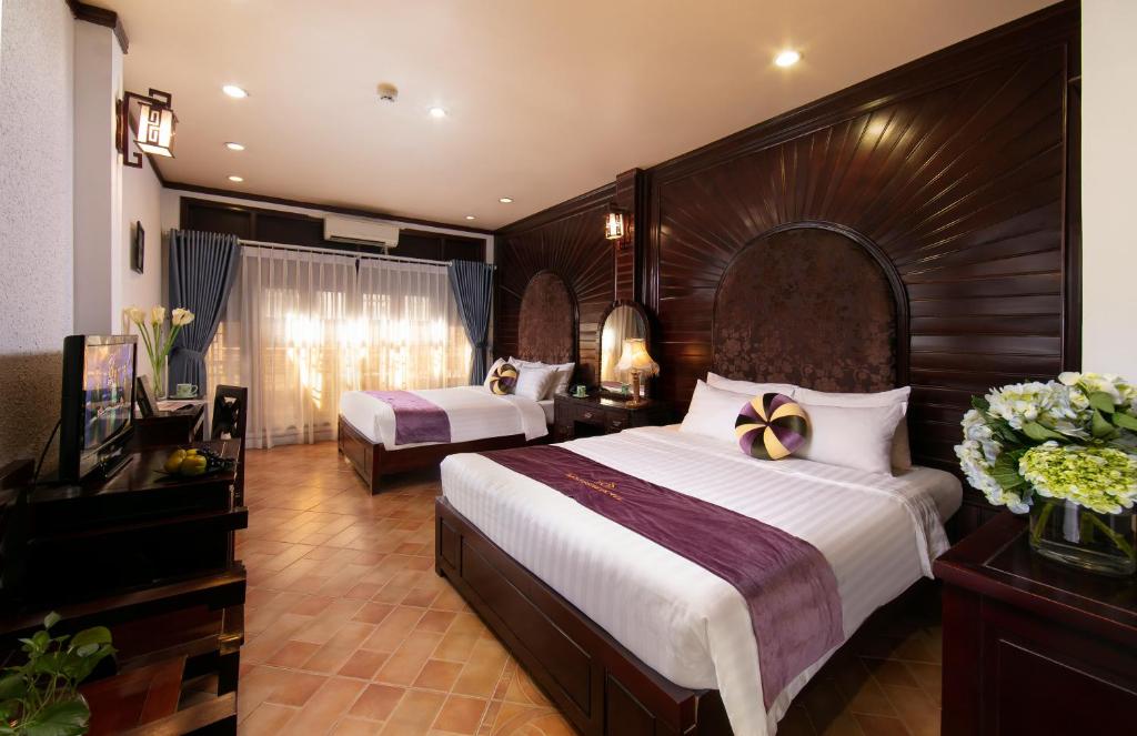 a hotel room with two beds and a television at Impressive Boutique Hotel in Hanoi