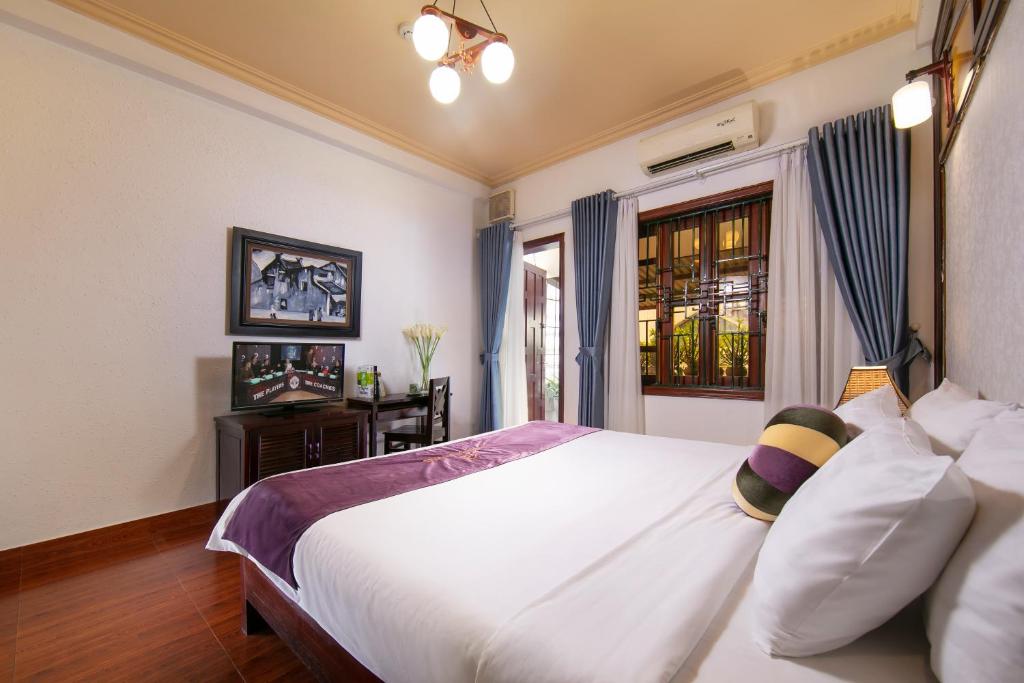 een slaapkamer met een groot wit bed en een raam bij Impressive Boutique Hotel in Hanoi