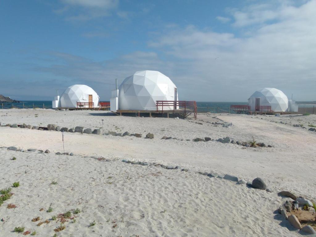 Tre cupole su una spiaggia con l'oceano sullo sfondo di Punta de domos a Punta de Choros