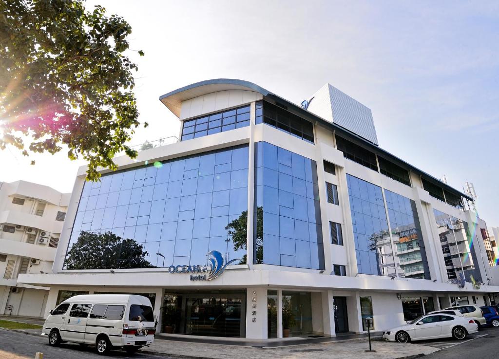 un edificio con una furgoneta estacionada frente a él en Oceania Hotel en Kota Kinabalu