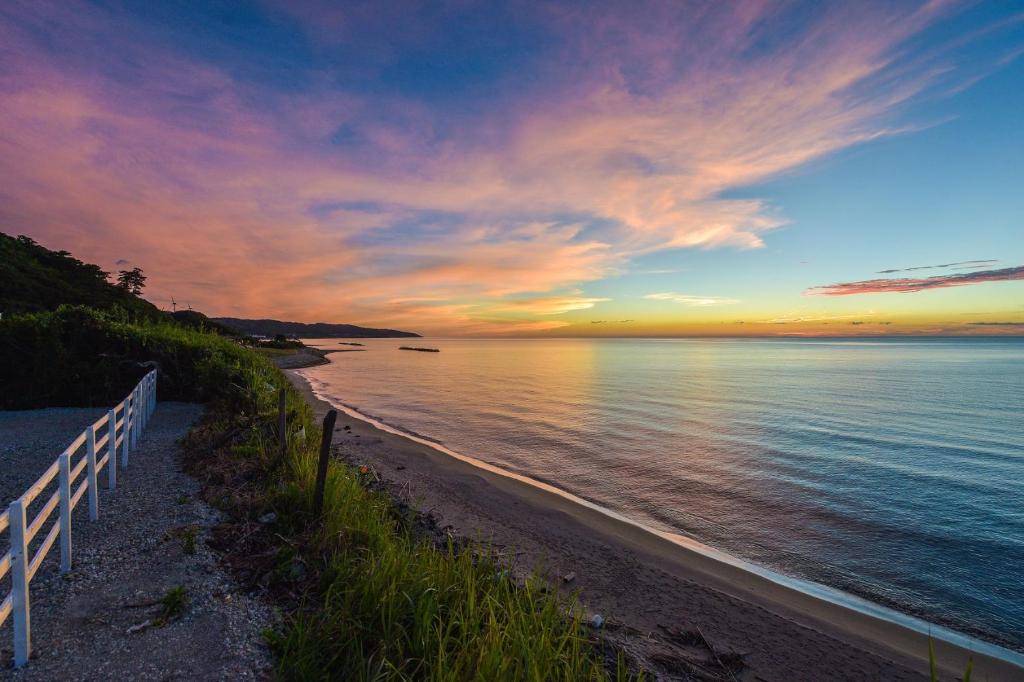 出雲市にあるOcean Base Hagane 鋼の塀と海を挟んだ海岸の夕日