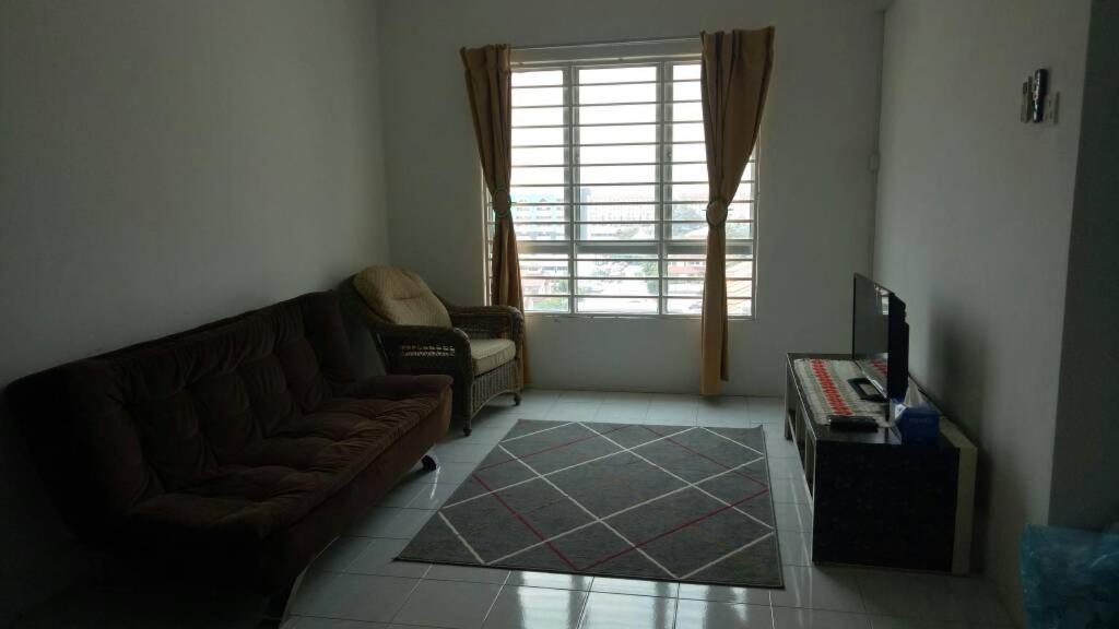 a living room with a couch and a window at Affordable Stay @ Rue’s Villa Tropika Apartment, UKM Bangi in Bangi