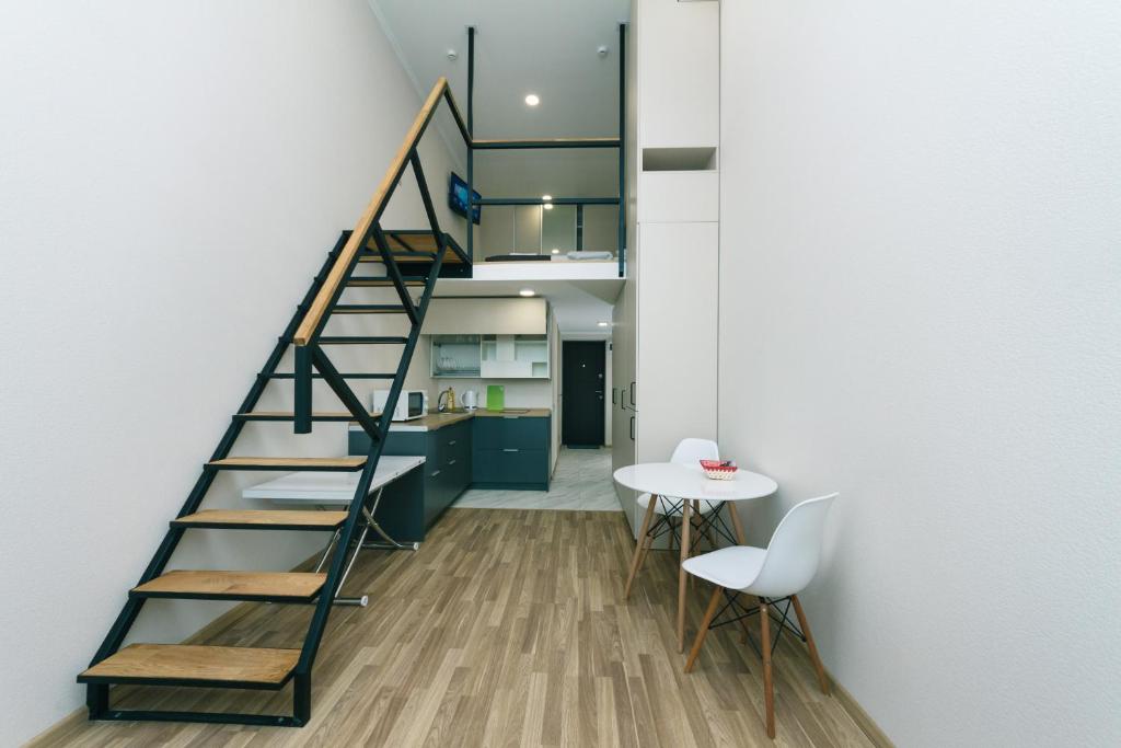 a staircase in a room with a table and a kitchen at BeRest Plus in Kyiv
