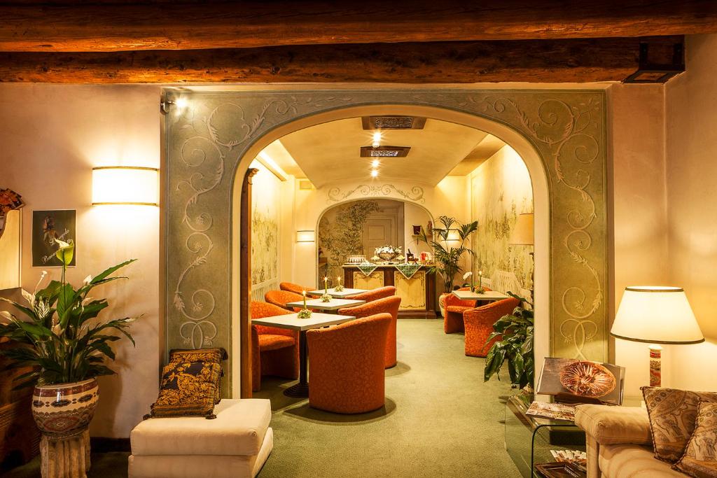 a living room with an archway with chairs and tables at Albergo Al Moretto in Castelfranco Veneto