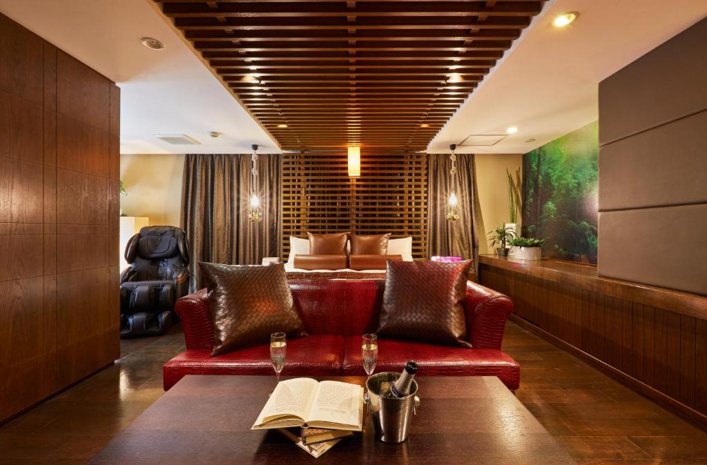 uma sala de estar com um sofá vermelho com um livro sobre uma mesa em HOTEL LOVE em Nagoia