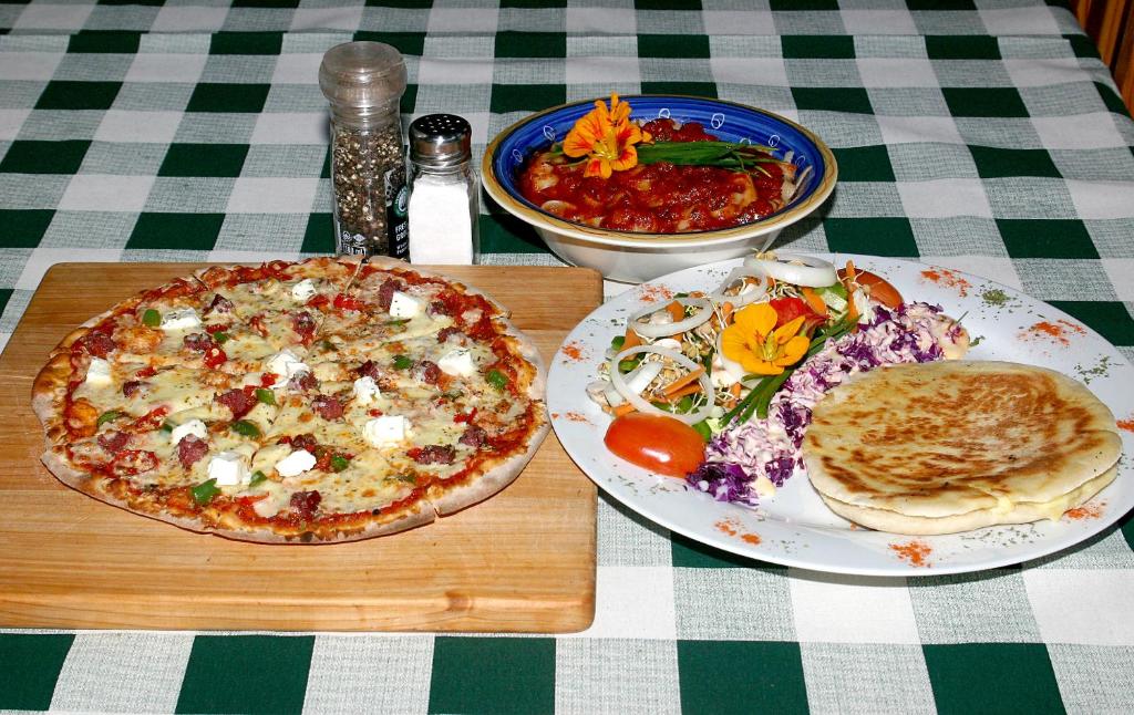 uma mesa com dois pratos de comida e uma pizza em Tower of Pizza em Ethels Drive