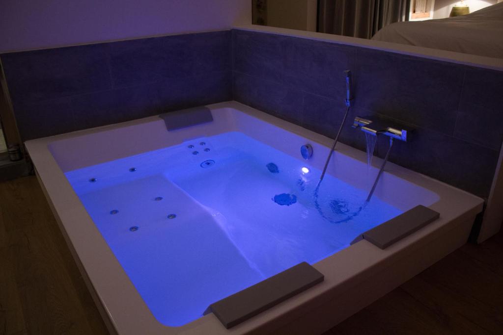eine Whirlpool-Badewanne mit blauer Beleuchtung in einem Zimmer in der Unterkunft Ker spa, gite avec spa privatif dans la chambre in Dol-de-Bretagne