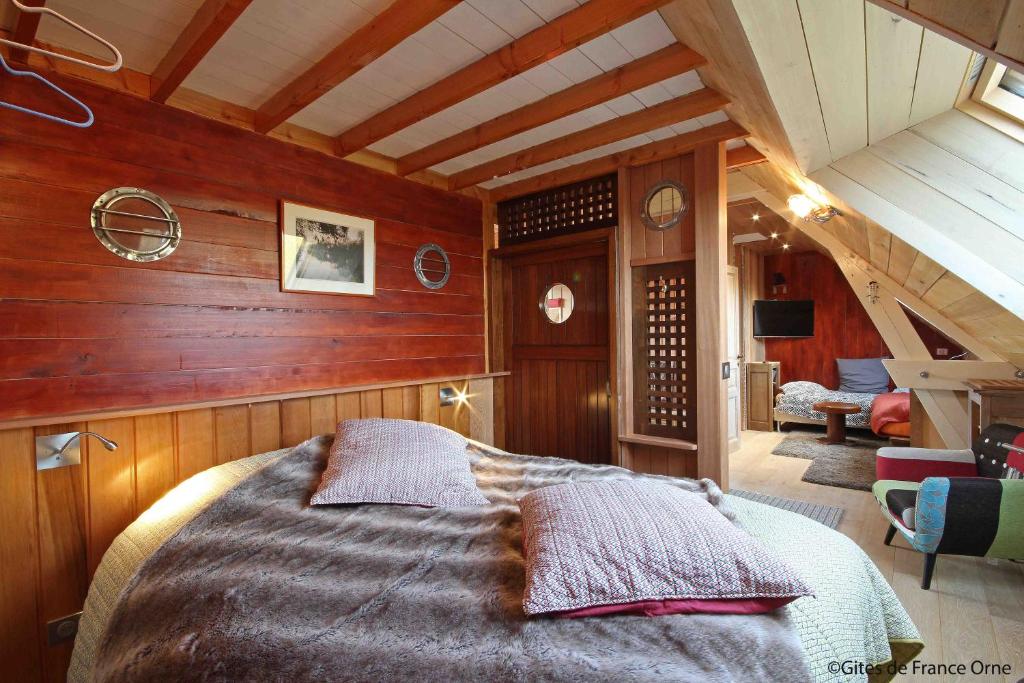 a bedroom with a bed in a room with wooden walls at La Cage aux Oiseaux in La Lande-de-Goult