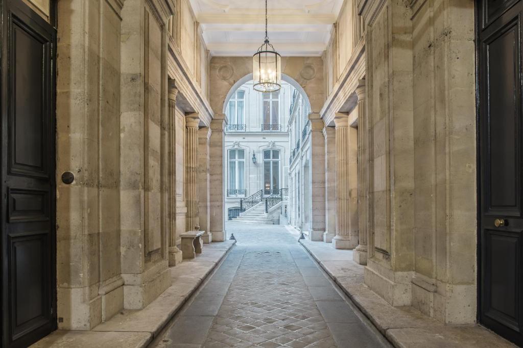 an empty hallway in a building with a chandelier at Hôtel Alfred Sommier in Paris